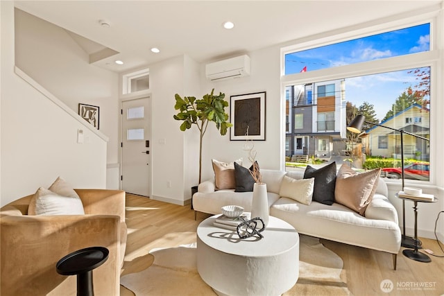 living room featuring baseboards, recessed lighting, wood finished floors, and a wall mounted air conditioner