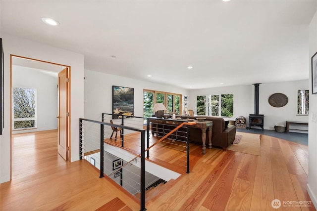 living room featuring a wood stove, light wood-type flooring, and recessed lighting