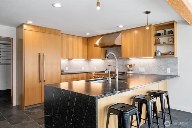kitchen with wall chimney exhaust hood, stainless steel countertops, modern cabinets, open shelves, and a breakfast bar area