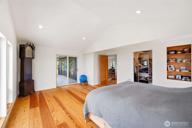 bedroom with access to outside, light wood finished floors, multiple windows, and lofted ceiling