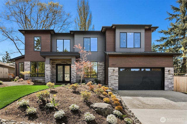 view of front facade featuring an attached garage, concrete driveway, and stone siding