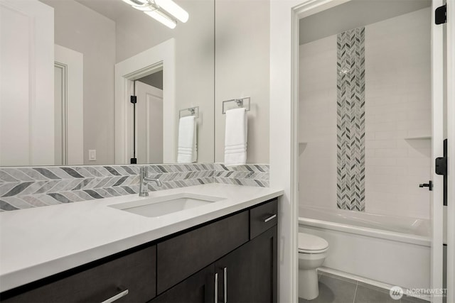 bathroom featuring tile patterned flooring, toilet, vanity, and shower / washtub combination