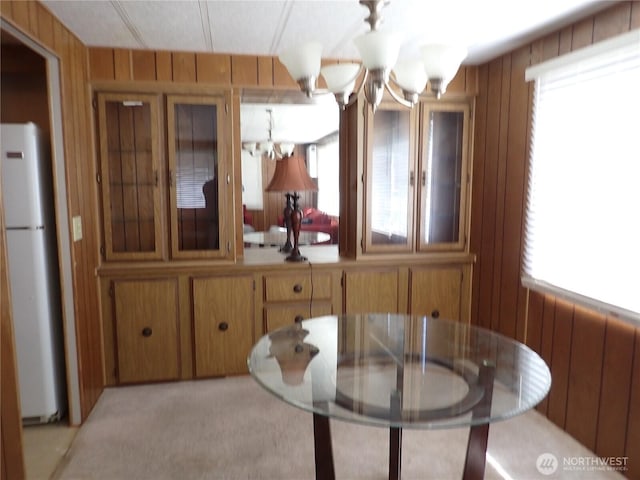 10515 60th Street Ct E Unit 165, Puyallup, WA 98372 - dining space featuring a chandelier, light colored carpet, and wood walls