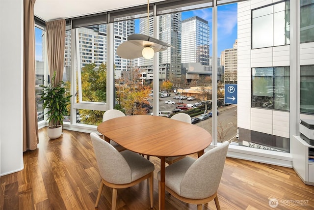 dining space with wood finished floors and a city view