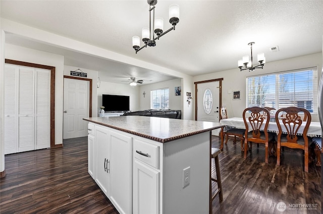 804 S Adams Ave, Warden, WA 98857 - kitchen with visible vents, open floor plan, dark wood finished floors, white cabinetry, and a kitchen island