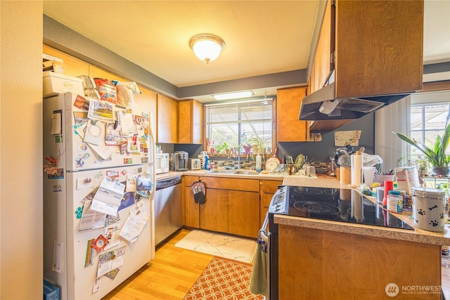 9941 Old Olympic Hwy, Sequim, WA 98382 - kitchen with white appliances, a sink, brown cabinets, light wood-style floors, and light countertops