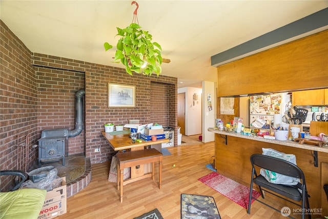 9941 Old Olympic Hwy, Sequim, WA 98382 - dining room with a wood stove, brick wall, and light wood finished floors