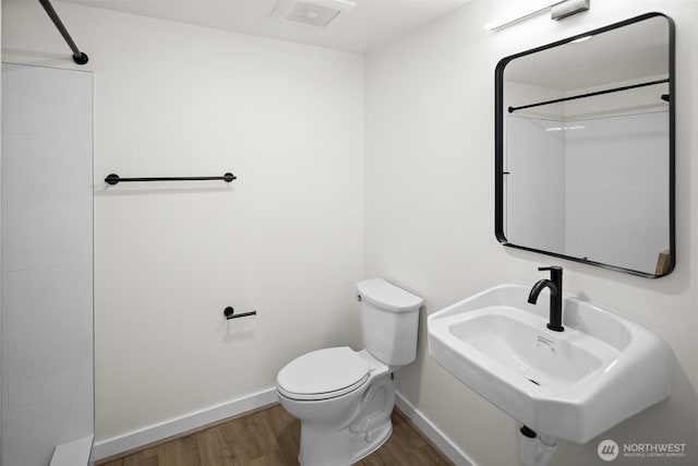 711 N 35th St, Seattle, WA 98103 - bathroom with toilet, wood finished floors, a sink, walk in shower, and baseboards