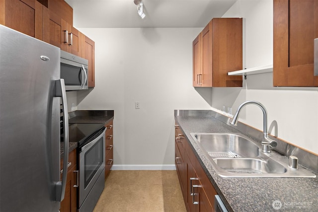 711 N 35th St, Seattle, WA 98103 - kitchen featuring brown cabinetry, dark countertops, a sink, and appliances with stainless steel finishes