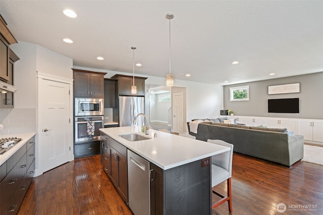 4407 N Ridgefield Woods Dr, Ridgefield, WA 98642 - kitchen with appliances with stainless steel finishes, a sink, light countertops, dark wood-type flooring, and open floor plan