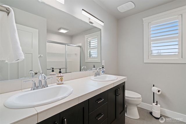 4407 N Ridgefield Woods Dr, Ridgefield, WA 98642 - bathroom featuring toilet, tile patterned floors, double vanity, a shower stall, and baseboards
