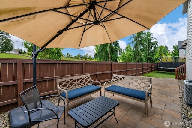 4407 N Ridgefield Woods Dr, Ridgefield, WA 98642 - fenced backyard with a trampoline, a patio area, an outdoor hangout area, and cooling unit