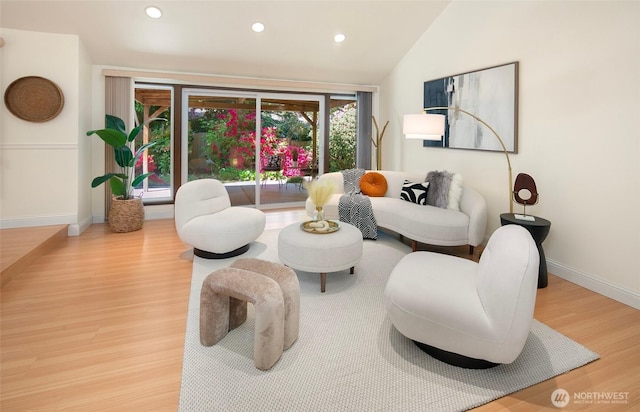 living area featuring wood finished floors, recessed lighting, baseboards, and vaulted ceiling