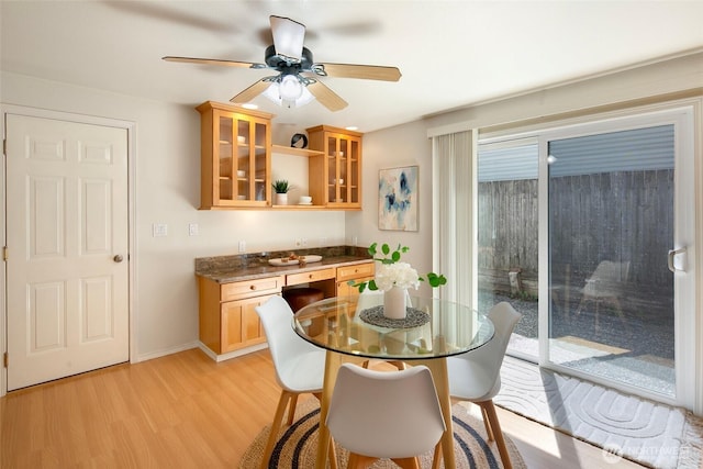 dining area featuring light wood-style floors, ceiling fan, and baseboards