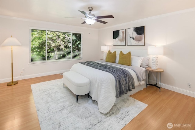 bedroom with baseboards, light wood finished floors, ornamental molding, and a ceiling fan