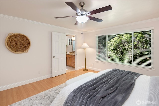 bedroom with light wood-style floors, crown molding, baseboards, a ceiling fan, and ensuite bath