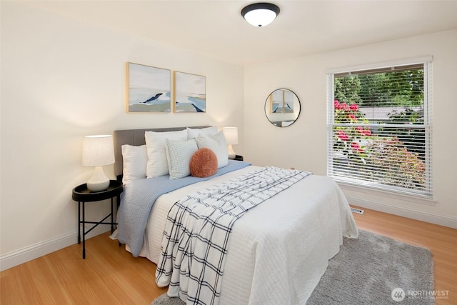 bedroom with wood finished floors and baseboards