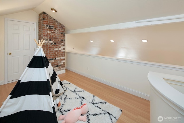 playroom with baseboards, light wood finished floors, and vaulted ceiling