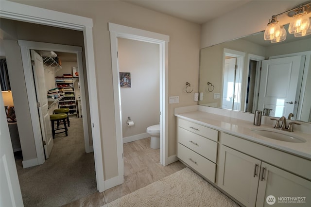 29027 NE 156th St, Duvall, WA 98019 - bathroom with baseboards, a spacious closet, toilet, vanity, and wood finished floors
