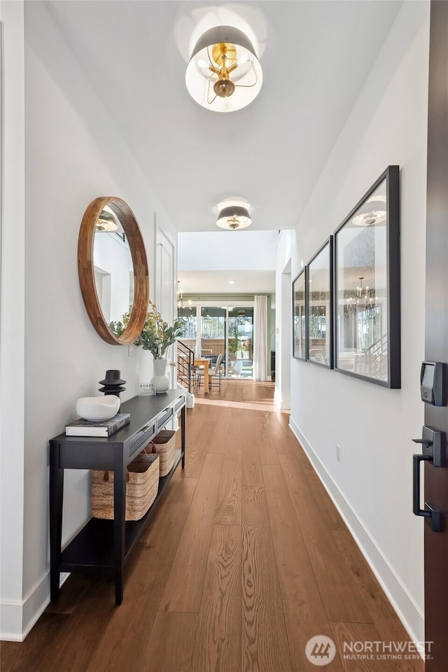 hallway featuring baseboards and hardwood / wood-style flooring