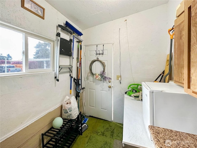 laundry room featuring laundry area and a textured wall