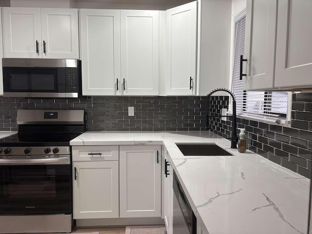 11703 NE 80th St Unit D3, Kirkland, WA 98033 - kitchen featuring white cabinetry, stainless steel appliances, decorative backsplash, and a sink