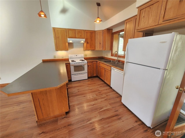 kitchen featuring light wood finished floors, under cabinet range hood, a sink, white appliances, and a peninsula