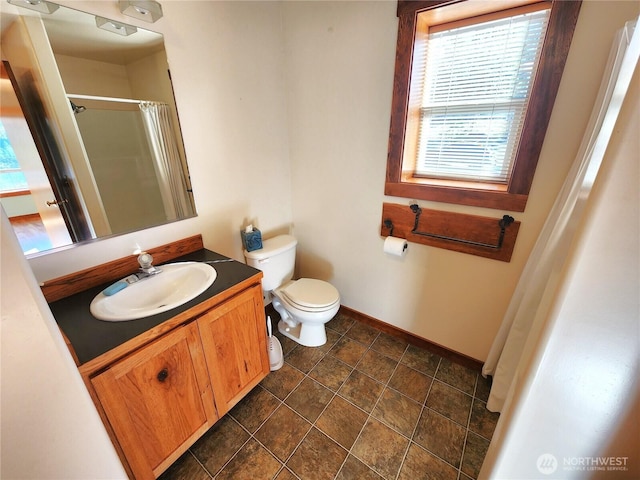 bathroom featuring toilet, vanity, curtained shower, baseboards, and stone finish floor