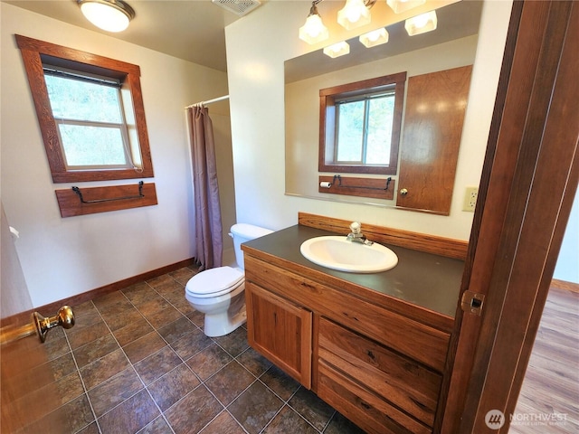full bathroom featuring vanity, a shower with curtain, baseboards, toilet, and visible vents