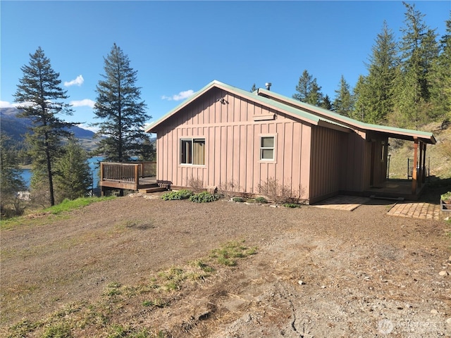 view of side of home with a deck with mountain view and board and batten siding