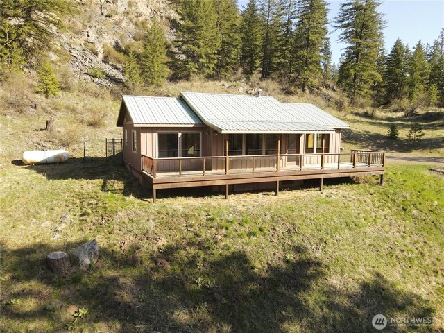 back of house featuring a wooden deck and metal roof