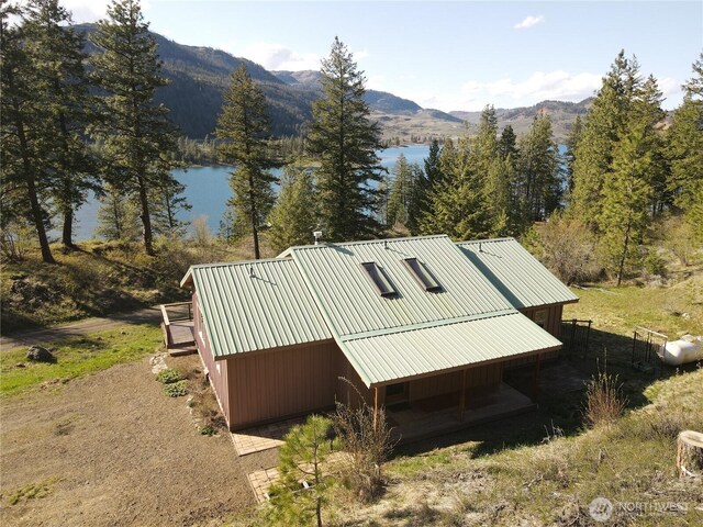 exterior space with a water and mountain view and metal roof