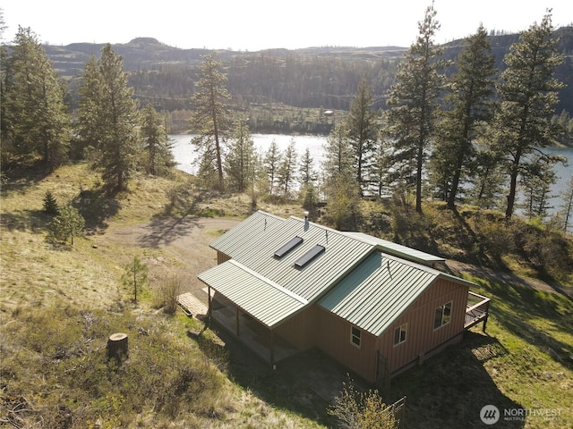 drone / aerial view with a forest view and a water view