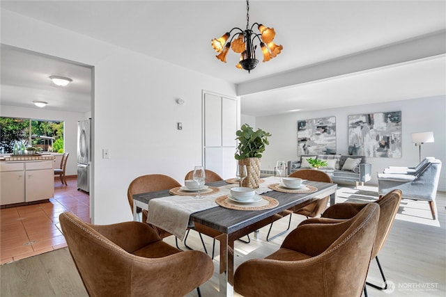 dining space with a chandelier and light wood-style flooring