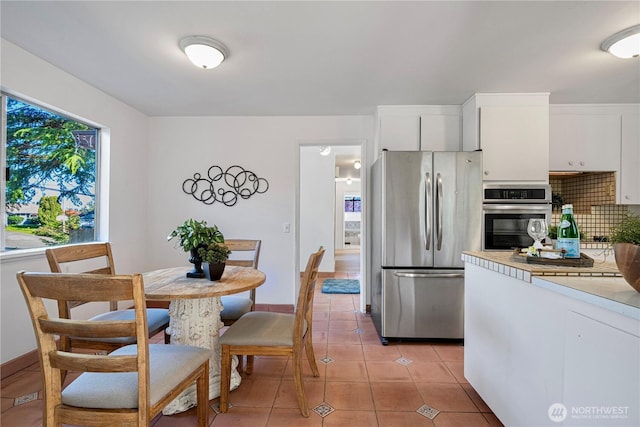 kitchen featuring light countertops, white cabinetry, light tile patterned flooring, and stainless steel appliances