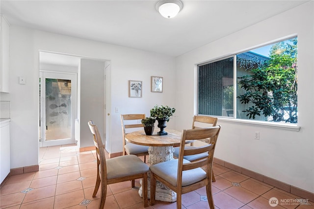 dining area featuring light tile patterned floors and baseboards
