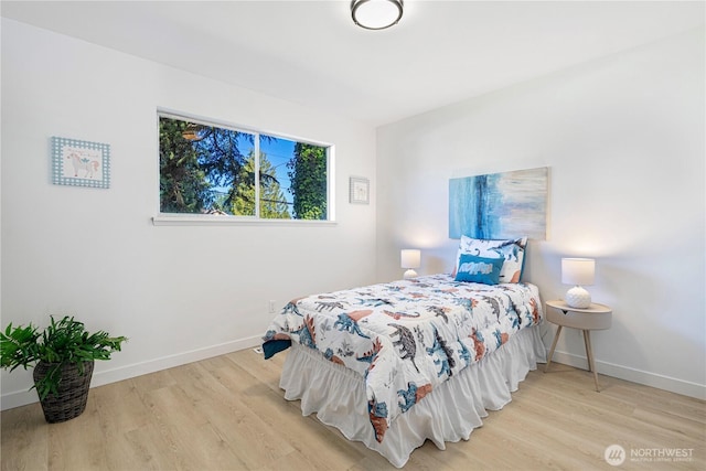 bedroom with baseboards and wood finished floors
