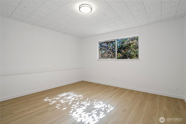 empty room with baseboards and wood finished floors