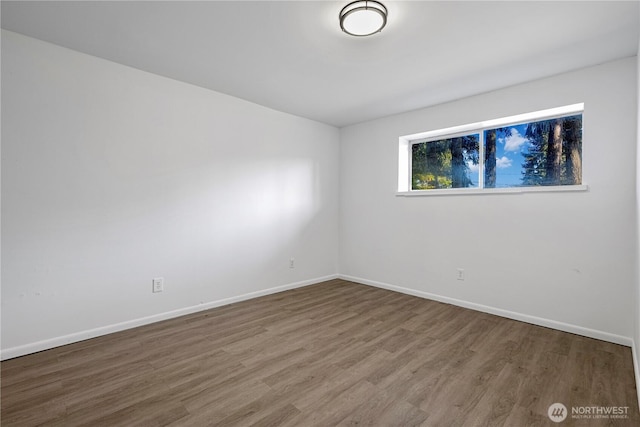 empty room featuring baseboards and wood finished floors