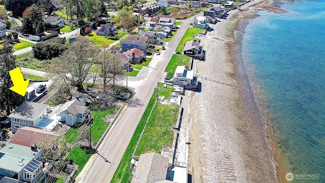 bird's eye view featuring a view of the beach, a residential view, and a water view