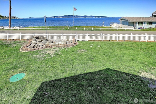view of yard with fence and a water view