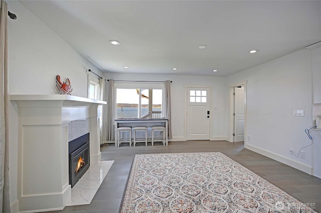 foyer with baseboards, recessed lighting, wood finished floors, and a fireplace