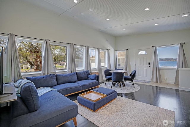 living room featuring a high ceiling, wood finished floors, and recessed lighting