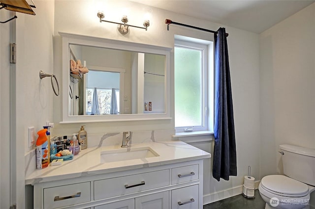 bathroom with a wealth of natural light, toilet, and vanity