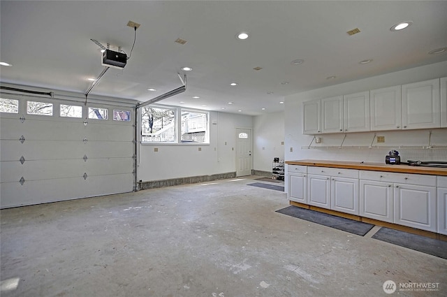 garage with a garage door opener and recessed lighting