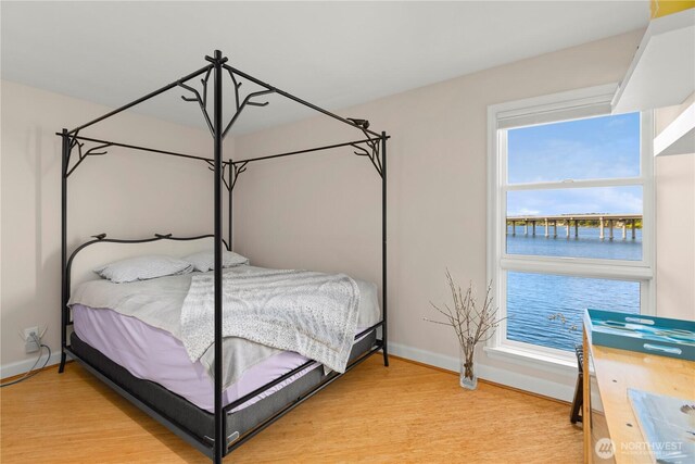 2360 43rd Ave E Unit 415, Seattle, WA 98112 - bedroom featuring baseboards, light wood-type flooring, and a water view