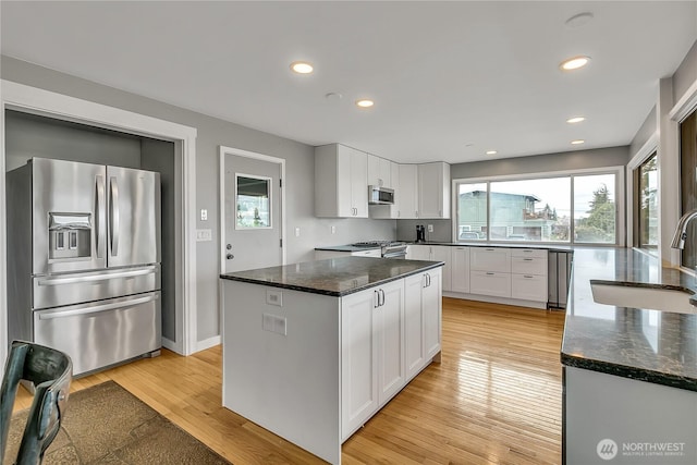 kitchen featuring white cabinets, appliances with stainless steel finishes, plenty of natural light, and a sink