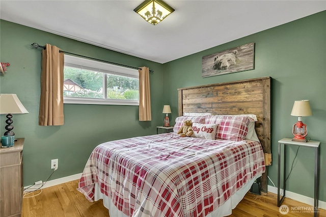 bedroom featuring baseboards and wood finished floors