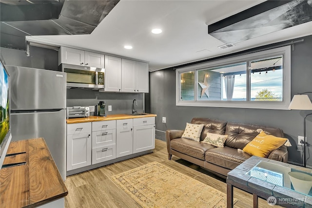 living room with a toaster, recessed lighting, light wood finished floors, and visible vents