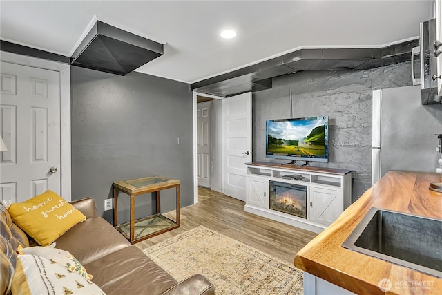 living room featuring a lit fireplace and light wood-type flooring
